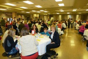 Emili koos oma venna ja vanaemaga Canyon Ridge High Schooli parimate õpilaste austamise banketil kooli sööklas, kus õpilasi ja nende peresid teenindavad kelneririietes õpetajad. 