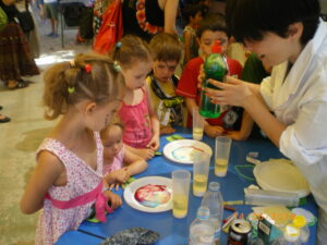 Igal kevadel on koolis avatud uste päev, millel lapsevanemad teevad töötube ning mis lõpeb suure veesõjaga, kus terve koolipere lastakse tuletõrjevoolikust veega üle. Lapsed ootavad seda väga. Fotol teevad Ursula ja Aurelia koos teiste lastega köögis leiduvate ainetega katseid.