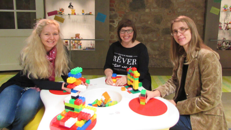 Tartu mänguasjamuuseumi direktor Triin Vaaro, giid-pedagoog Ave Viirma ning teadur ja peavarahoidja Helena Grauberg proovisid näitusel ka ise legodest meisterdada. Foto: Tiina Vapper